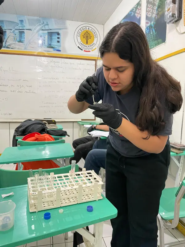 Aluna do Ensino Médio em aula prática de laboratório
